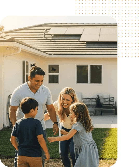 Family enjoying sunny day outside a house with solar panels on the roof.